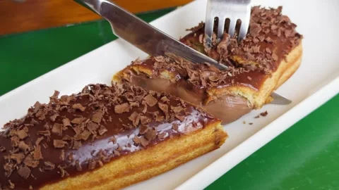 Fresh sweet eclair cake with cream cheese and chocolate chips on the table in a Stock Footage 335693846