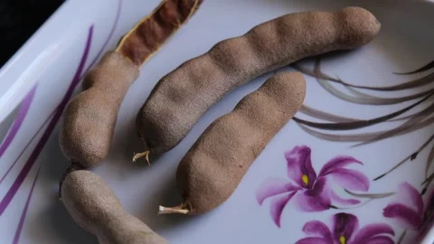 Fresh Tamarind Pods on Floral Patterned Tray Vidéo 331621344