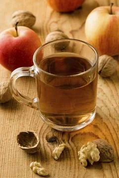 Fresh tea with apples and nuts on wooden table Stock Photos