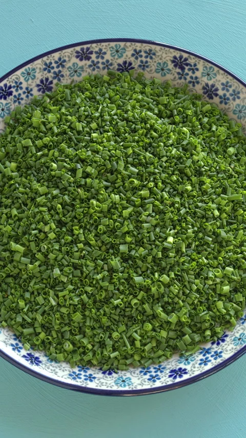Fresh, thinly chopped chives on a plate. Vertical video. Stock-Footage 333519254