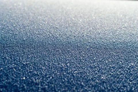 Fresh tiny ice crystals on the surface of shiny metal. Narrow Depth of Field  Stock Photos