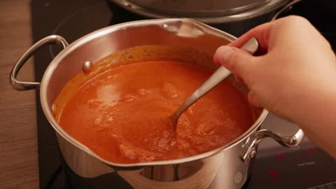 Fresh tomato and red bell pepper soup boiling in pot with steam rising. Stock Footage 341361407