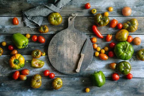 Fresh tomatoes and peppers on rustic wooden background. Stock Photos