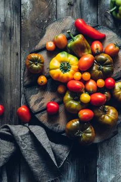 Fresh tomatoes and peppers on rustic wooden background Stock Photos