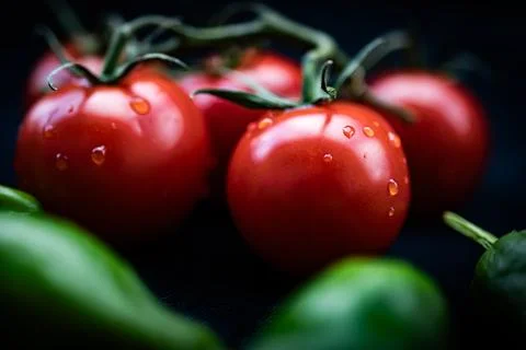 Fresh tomatoes on a black background. Selective focus. Toned Stock Photos