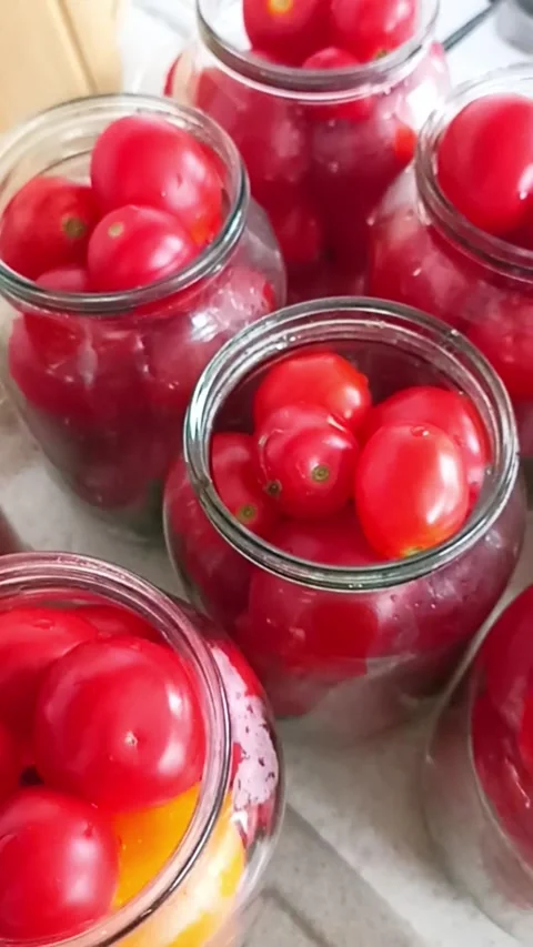 Fresh tomatoes packed in glass jars for homemade canning Видео 345326552