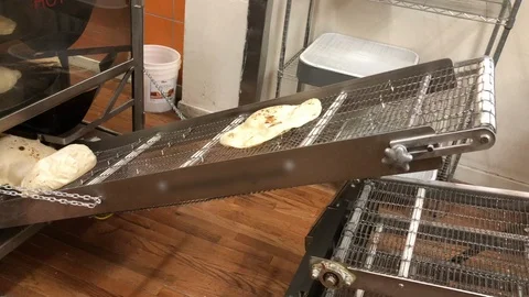 Fresh Tortillas going down the Convayor Belt after being cooked Stock Footage 107154527