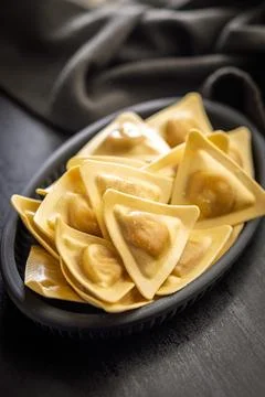 Fresh Triangular Ravioli On Black Plate - Golden Filled Pasta For Italian C.. Stock Photos