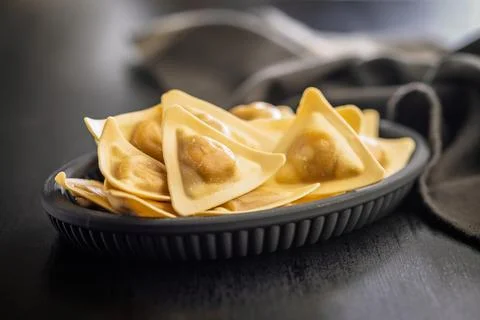Fresh Triangular Ravioli On Black Plate - Golden Filled Pasta For Italian C.. Fotos de archivo