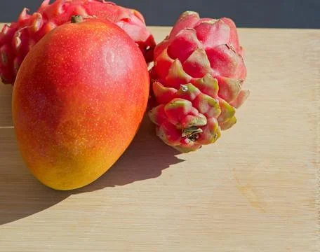 Fresh tropical fruit including one mango and two dragon fruit Stock Photos