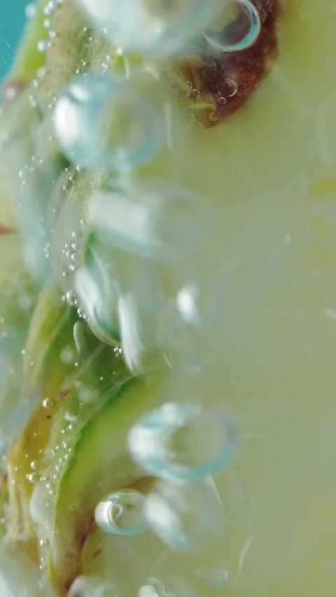 Fresh tropical pineapple fruit slice underwater in clear bubbling water against Stock Footage 346774403