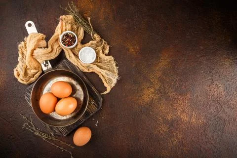 Fresh uncooked egg on a pan, stone or concrete background. Stock Photos