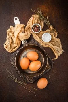 Fresh uncooked egg on a pan, stone or concrete background. Stock Photos