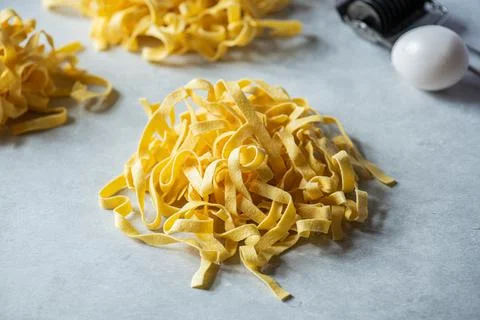 Fresh uncooked pasta nests on a gray background. Close up. Stock Photos