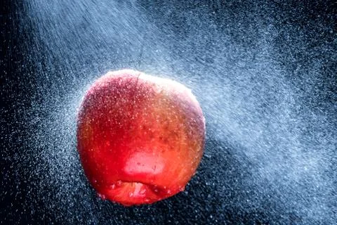 Fresh  Variegated apple  gets sprayed with water on black background. Concept Stock Photos
