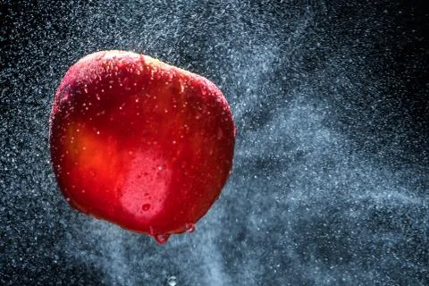Fresh  Variegated apple  gets sprayed with water on black background. Concept Stock Photos
