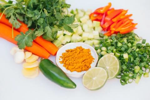 Fresh vegetable assortment on white background. Greenery, cut limes, pepper,  Stock Photos