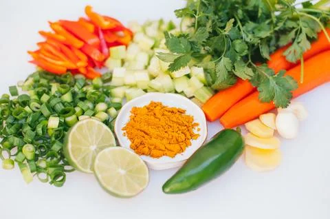 Fresh vegetable assortment on white background. Greenery, cut limes, pepper.. Stock Photos