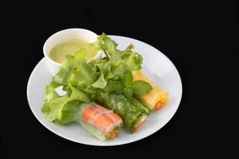 Fresh vegetable noodle spring roll with sauce on plate, Salad roll, On a blac Stock Photos