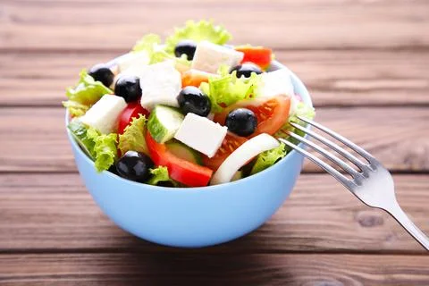 Fresh vegetable salad with fork on brown wooden background Foto stock