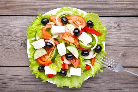 Fresh vegetable salad with fork on grey wooden background Stock Photos