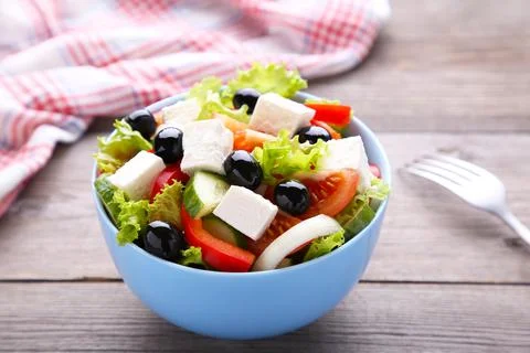 Fresh vegetable salad with fork on grey wooden background Stock Photos