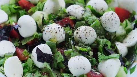 Fresh vegetable salad with mozzarella cheese balls is pouring olive oil. Stock Footage 202011603