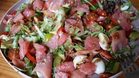 Fresh vegetable salad with salmon. Arugula, grapefruit, cherry tomatoes, quail e Stock Footage 275497853