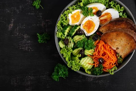 Fresh Vegetable Salad with Soft Boiled Eggs and Rustic Bread. Top view, fla.. Stock Photos