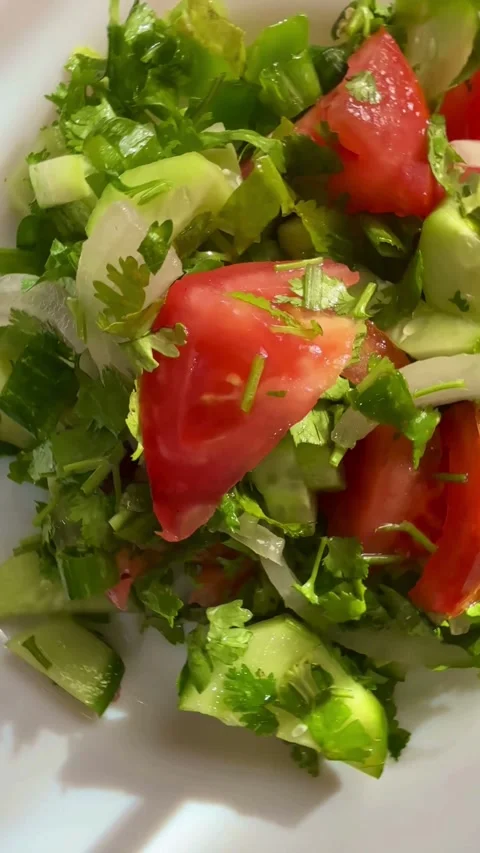 Fresh vegetable salad with tomatoes cucumbers onions and cilantro Stock Footage 331976200