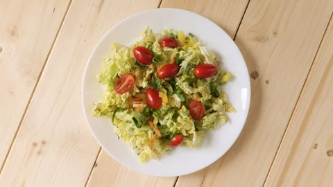 Fresh vegetable salad with tomatoes rotating on a plate Stock Footage 337885923