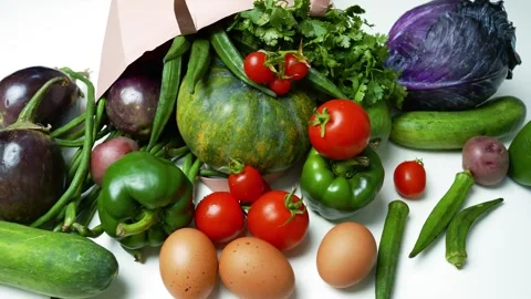 Fresh Vegetables and Eggs Spilling from a Paper Bag, A variety of fresh veg.. 動画素材 305053640