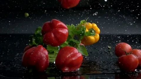 Fresh vegetables and herbs falling with water in slow motion Stock Footage 72359512