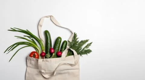 Fresh vegetables and herbs in a string bag made of natural materials, eco-fri Stock Photos
