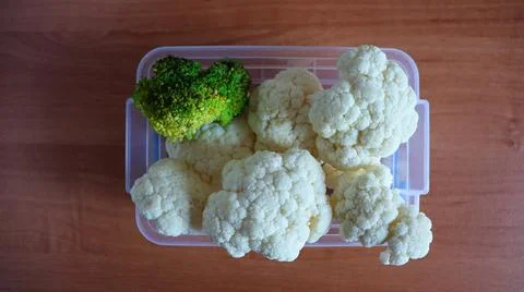 Fresh vegetables in a container on the table showing broccoli and cauliflower Stock Photos