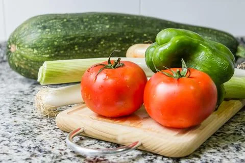 Fresh vegetables on cutting board in the kitchen Stock Photos