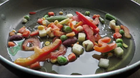 Fresh vegetables falling into a pan with oil Stock Footage 63306777