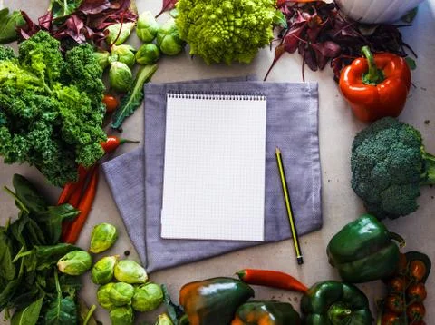 Fresh vegetables flatlay overhead frame. Notebook with vegetables.. Food layo Stock Photos