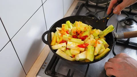 Fresh vegetables including squash and peppers are being expertly stir-fried in a Video stock 316483089