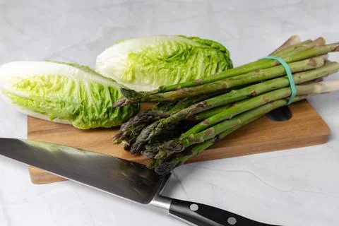 Fresh vegetables on the kitchen table cabbage, salad, asparagus. Stock Photos