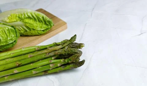 Fresh vegetables on the kitchen table cabbage, salad, asparagus. Stock Photos