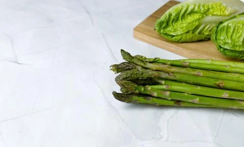 Fresh vegetables on the kitchen table cabbage, salad, asparagus. Stock Photos