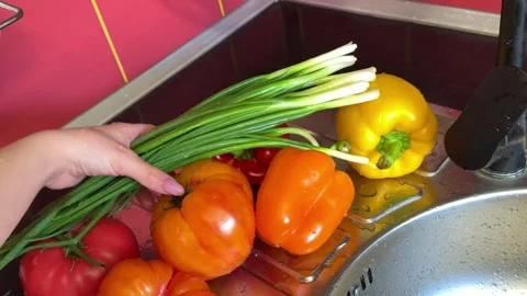 Fresh vegetables in modern rustic kitchen with tomatoes bell peppers and green Stock Footage 345722372