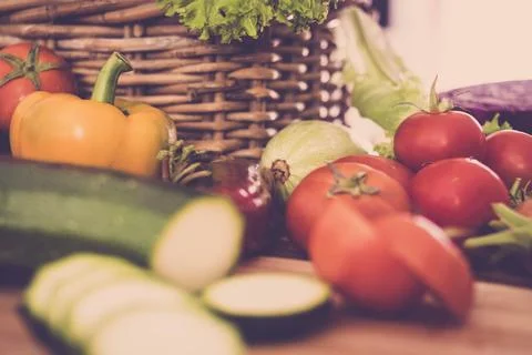 Fresh vegetables in a rustic basket with tomatoes, zucchini and bell pepper.. Stock Photos