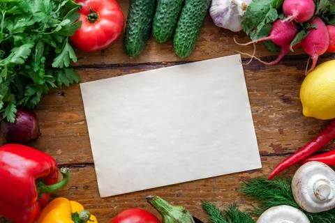 Fresh vegetables on rustic surface with space for your recipe on paper Stock Photos