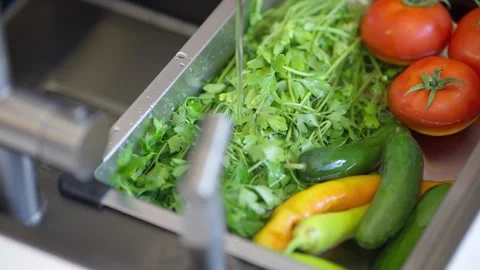 Fresh vegetables soaking in a kitchen sink before cooking Stock Footage 336493135