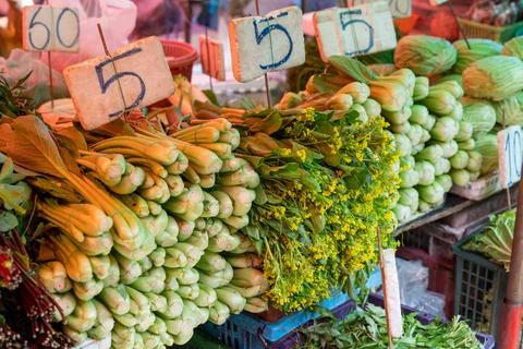 Fresh vegetables stacked on stall table at Bangkok market Stock Photos