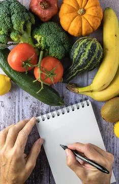 Fresh vegetables, two hands and a notepad, healthy food concept and new yea.. Foto stock