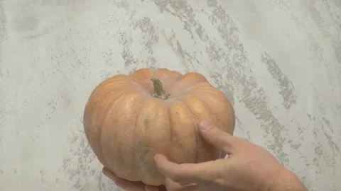 A Fresh, Vibrant Pumpkin Held Up Against a Beautifully Textured and Engaging Видео 285317155