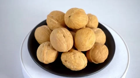 Fresh walnut in black plate rotating Stock Footage 293619020